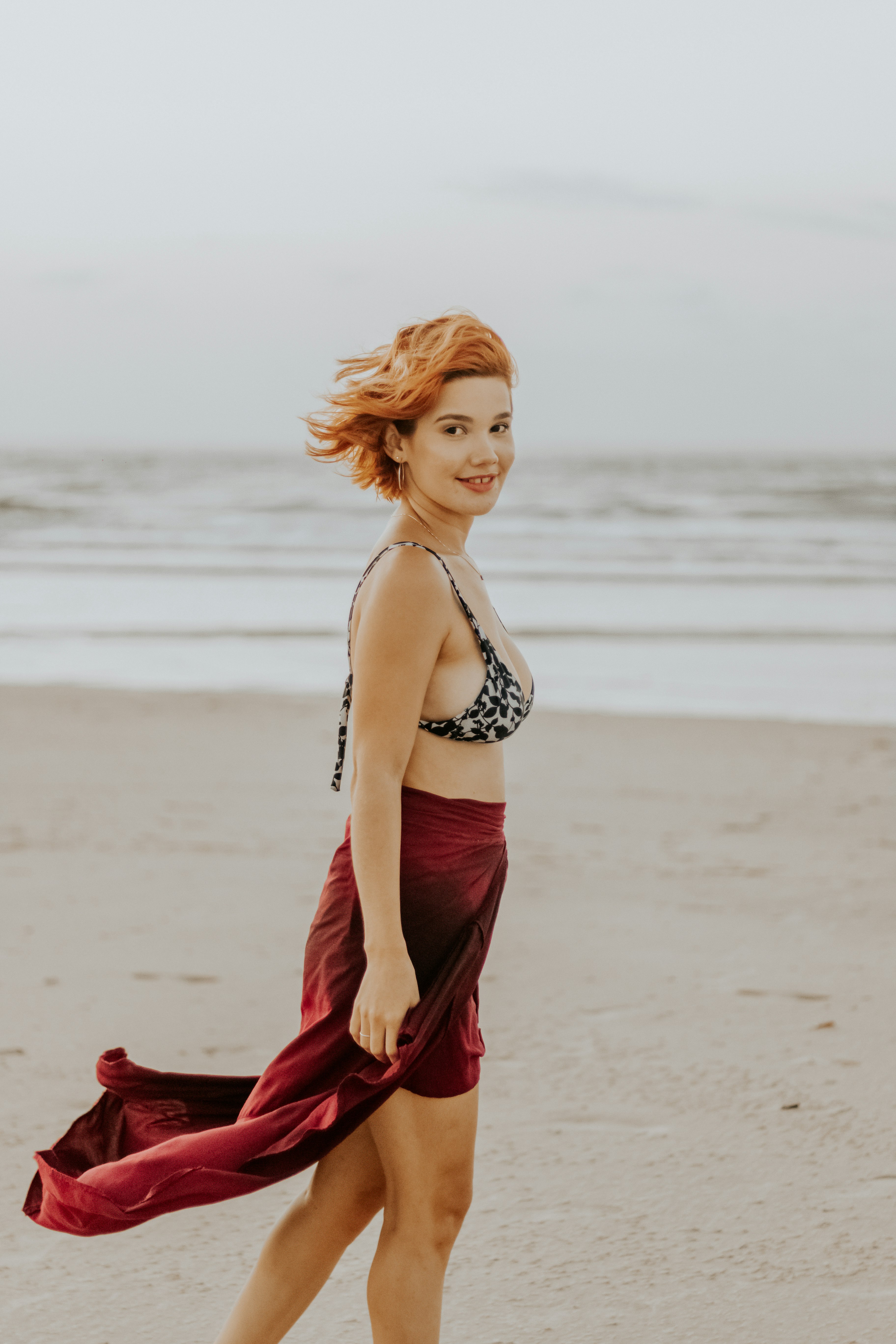 woman in black bikini standing on beach during daytime